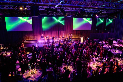 Guests at the Winter Ball chatting around their tables and dancing to the band