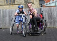 Paralympic Gold medalist Sophie Christiansen visiting the Petra running bike project in Sussex. Sophie is in her wheelchair next to a little girl with cerebral palsy trialling one of the bikes