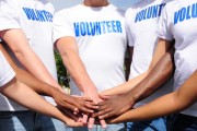 Volunteers putting their hands all into the middle on top of eachother